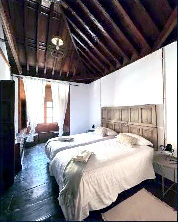 Dormitorio de Casa La Aldaba con techo de madera tradicional